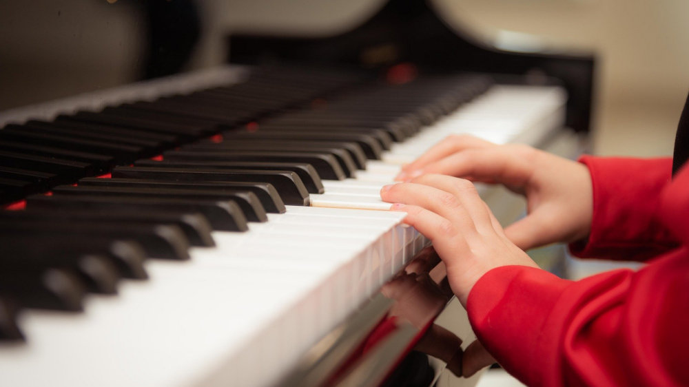 Child’s hands on piano keyboard